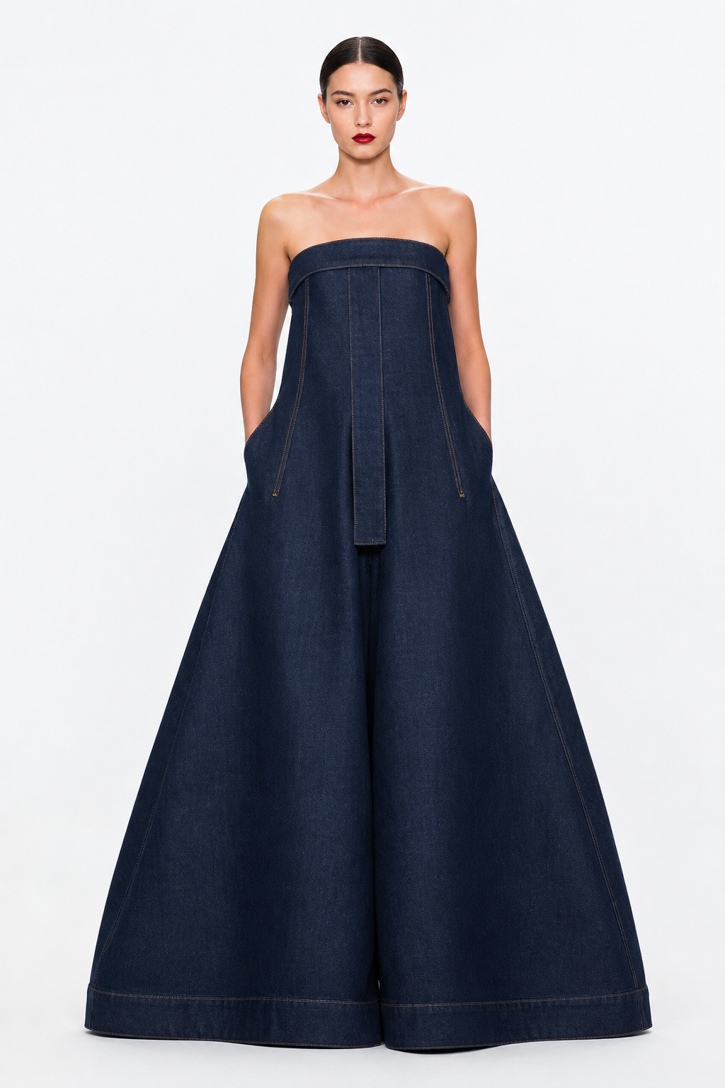 Enterizo Ara — Enterizo strapless en denim de alta densidad, torso riguroso, pernera monumental de amplitud extrema, bolsillos utilitarios, faja central estructurada, cierre trasero.